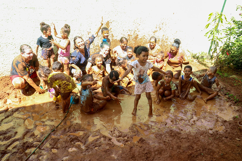 Paula Belmonte entra na brincadeira e participa de banho de lama com crianças em escola